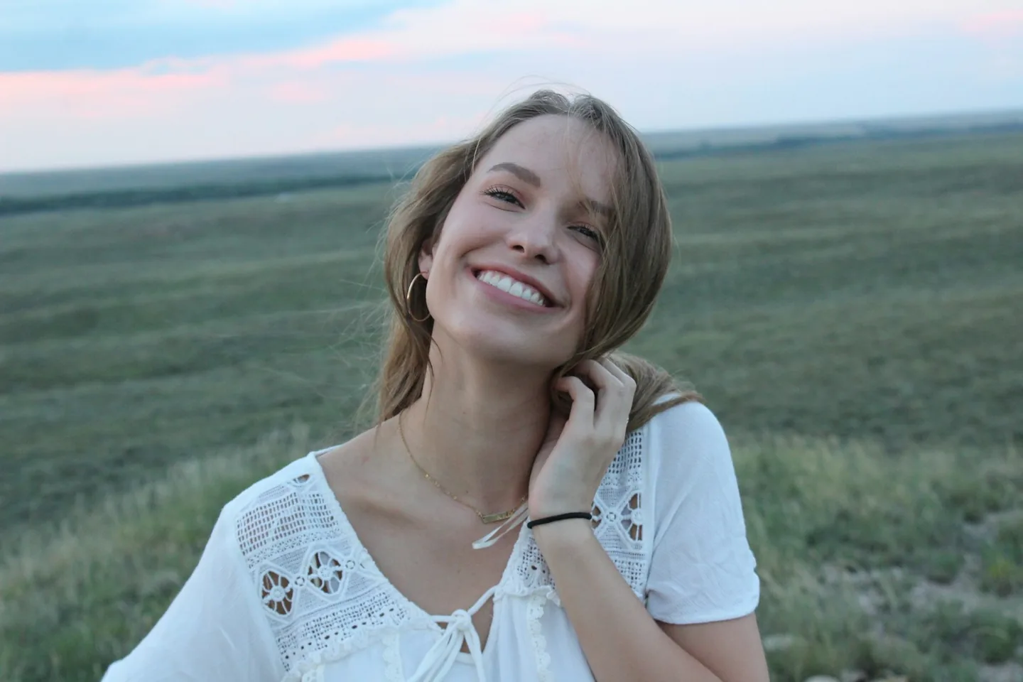 Woman smiling naturally outdoors while considering a tooth gap preview